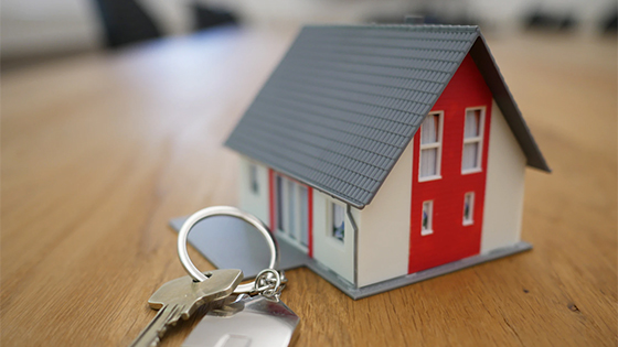 red and white miniature house on a wooden table with house keys; image used for blog post understanding fair market value rules