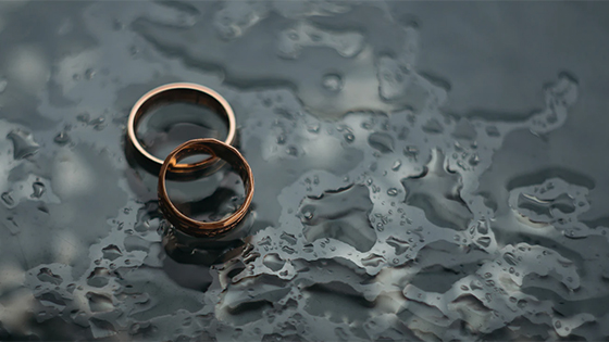 two gold rings sitting on the ground surrounded by rain; image used for blog post about tax issues for divorced couples two gold rings sitting on the ground surrounded by rain; image used for blog post about tax issues for divorced couples