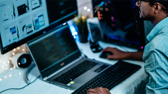 man in blue dress shirt and glasses using computer; image used for blog post about work-from-home not-for-profits