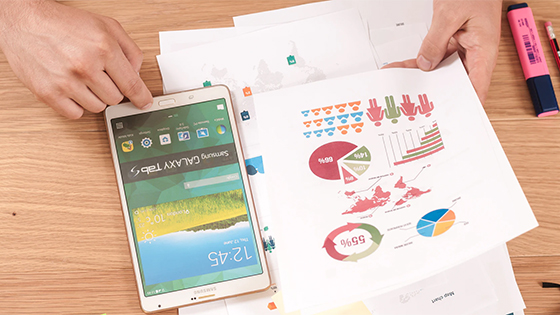 man looking at documents with data and charts; image used for blog post about benchmarking for not-for-profits