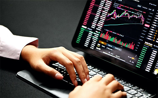 person working on a laptop with cryptocurrency rates and data on screen; image used for blog post about IIJA digital asset reporting requirements