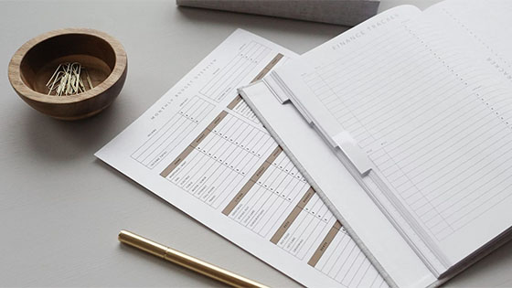 a calendar booklet sits on top of a monthly budget sheet with a pencil; image used for blog post about budgeting ideas for not-for-profits