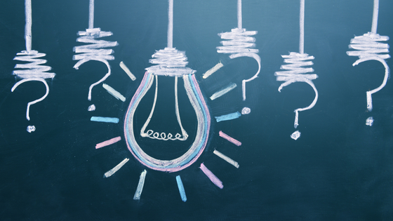 An image of a chalkboard with drawings of question marks and lightbulbs; image used for blog post about understanding charitable donor motivation