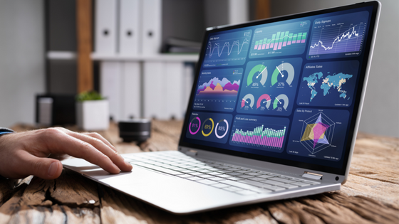 An image of someone looking at a laptop with graphs and data on the screen; image used for blog post about tracking KPIs with a financial dashboard
