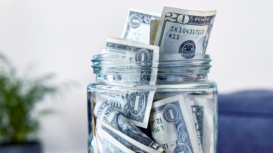 An image of dollar bills stuffed into a glass jar; image used for blog post about not-for-profit operating reserves