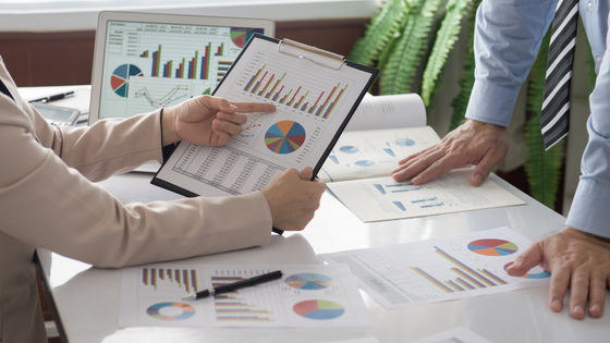 An image of two people looking at data and graphs on documents; for blog post about how not-for-profits can evaluate their grants