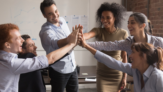 A photo of a group of team members giving a group high five; for blog post about not-for-profits connecting with giving circles